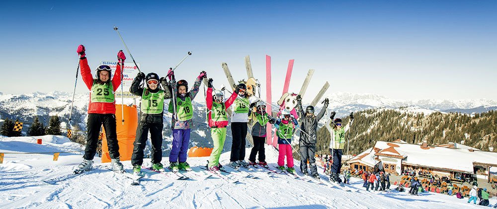 Eine Skikurs-Gruppe mit Skilehrerin der Absolut School auf der Piste.